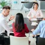 Team diskutiert gemeinsam Aufgaben und zeigt kommunikative Soft Skills im österreichischen Arbeitsalltag