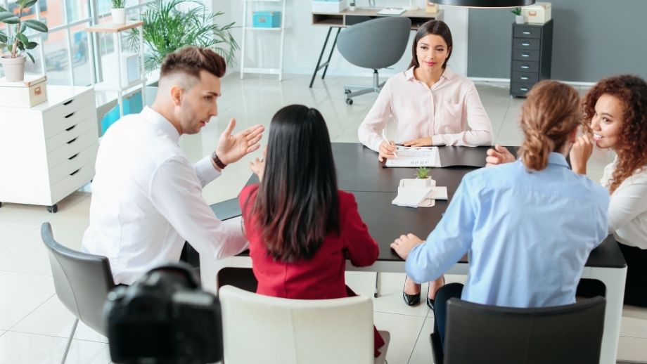 Team diskutiert gemeinsam Aufgaben und zeigt kommunikative Soft Skills im österreichischen Arbeitsalltag