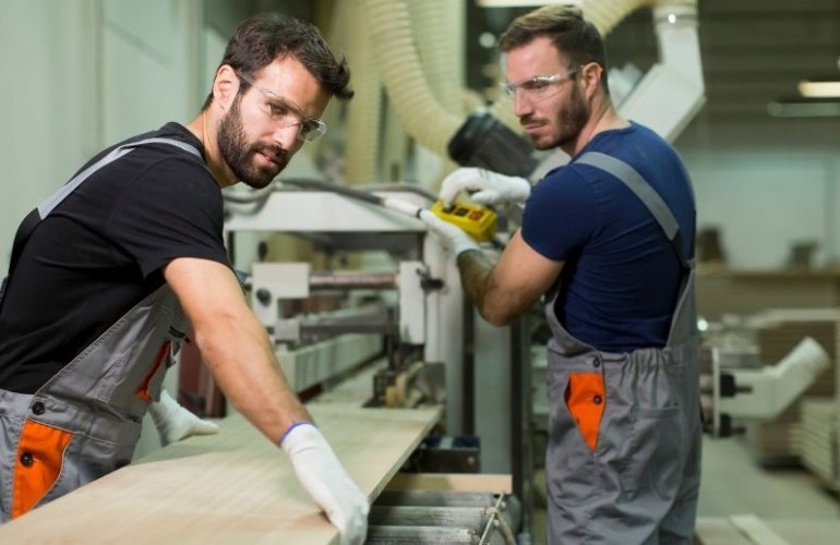 Mitarbeiter arbeiten gemeinsam in einem Produktionsumfeld im Rahmen der Arbeitnehmerüberlassung in Österreich