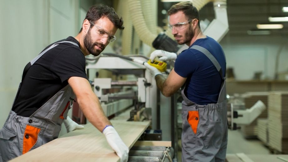 Mitarbeiter arbeiten gemeinsam in einem Produktionsumfeld im Rahmen der Arbeitnehmerüberlassung in Österreich